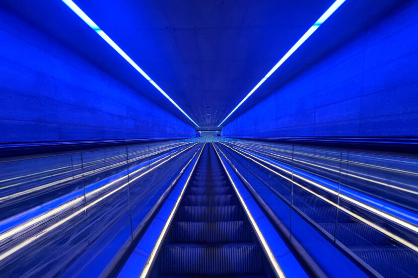 Blau beleuchtete Rolltreppe zur U-Bahnstation Gammel Strand in Kopenhagen mit futuristischer Perspektive