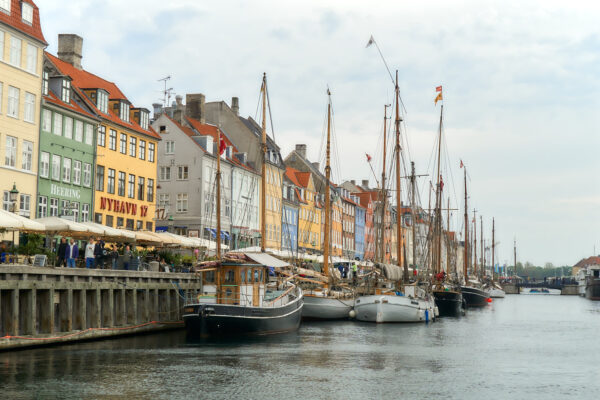 Bunte Häuser und historische Segelschiffe entlang des Nyhavn-Kanals in Kopenhagen an einem ruhigen Tag