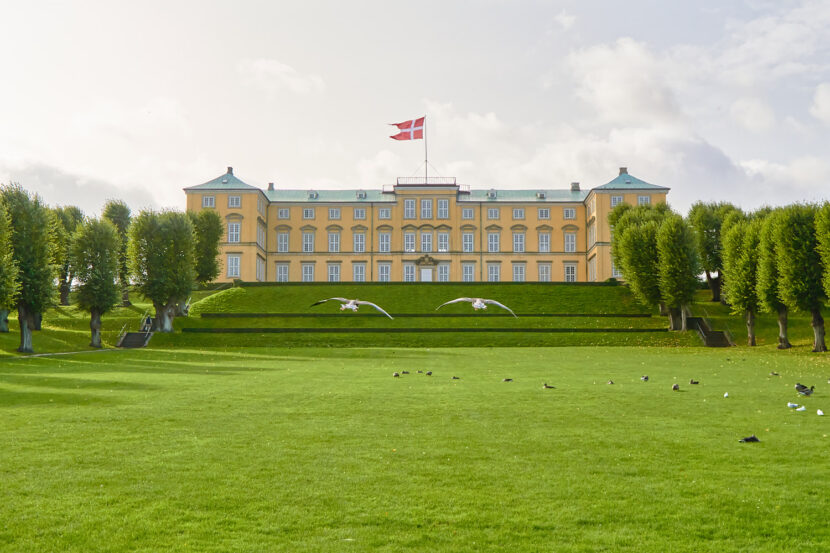 Frederiksberg Slot in Kopenhagen mit gepflegten Parkanlagen, dänischer Flagge und fliegenden Gänsen.