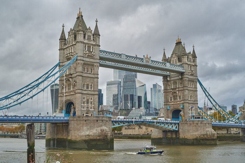 Das Foto zeigt die Tower Bridge, die über die Themse führt. Das Foto ist von der gegenüberliegenden Seite des Tower of London aufgenommen. Im unteren Teil des Bildes sieht man ein Polizeiboot, das kurz vorher unter der Brücke hindurch gefahren ist.