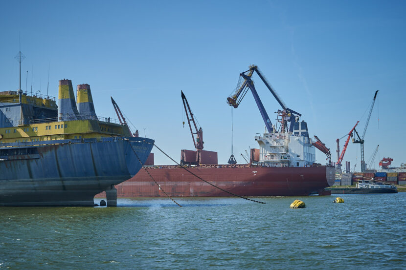 Bild vom Hafen in Rotterdamm, es zeigt zwei große Frachtschiffe sowie im HIntergrund auch Kräne und Container.