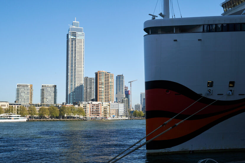 Blick vom Cruise Terminal Rotterdam auf ein Kreuzfahrtschiff und die moderne Skyline entlang der Maas
