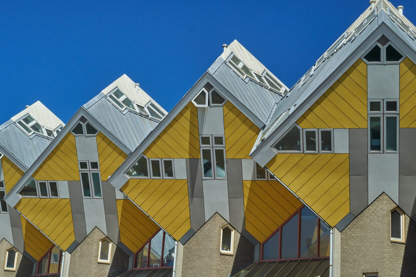 Einige der gelben Kubushäuser in Rotterdam vor blauem Himmel.
