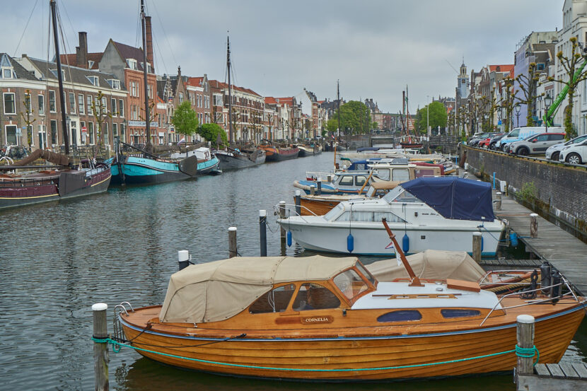 Historische Boote im Hafen von Delfshaven in Rotterdam, gesäumt von alten Häusern und ruhigem Wasser