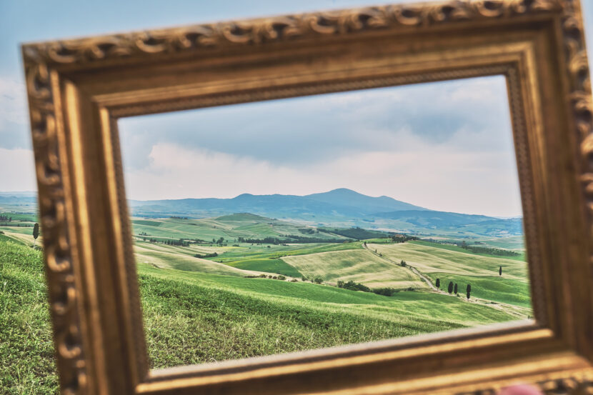 Sanfte Hügel des Val d’Orcia, eingerahmt von einem Bilderrahmen, unter dramatischem Himmel in der Toskana