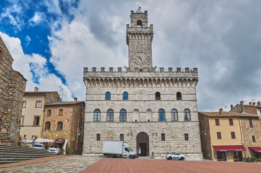 Historischer Palazzo Comunale auf der Piazza Grande in Montepulciano unter dramatischem Wolkenhimmel